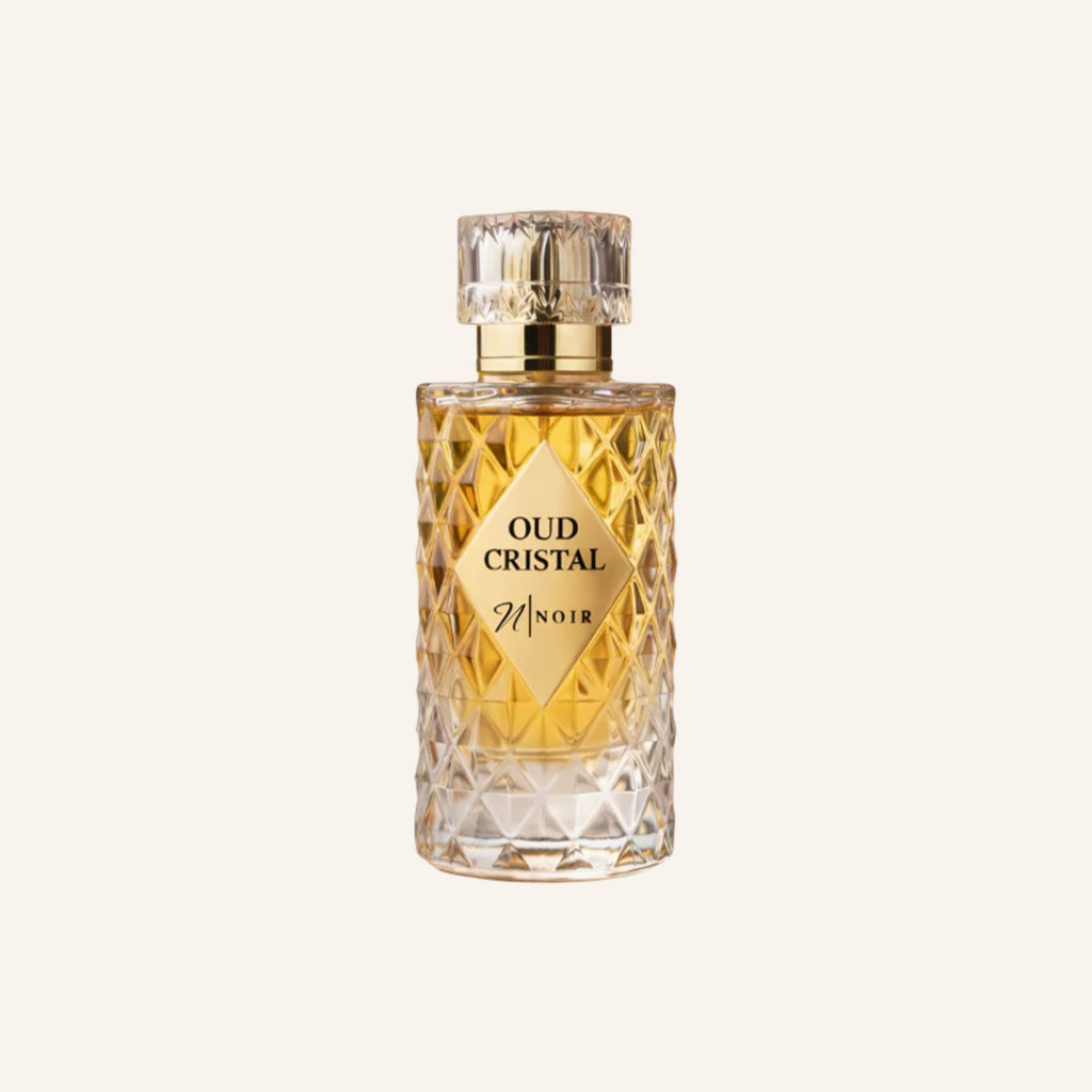 Perfume bottle labeled 'Oud Cristal Noir' on a light beige background