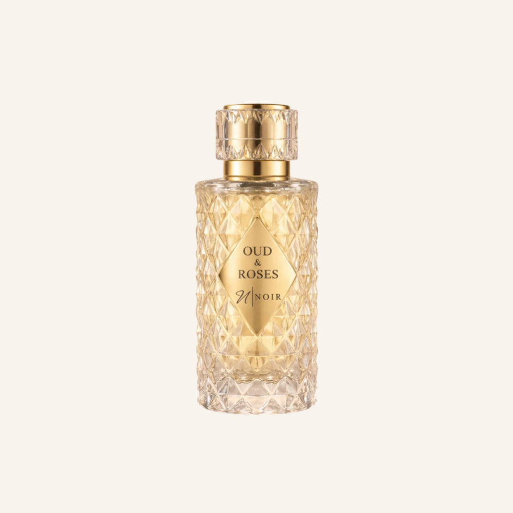 Perfume bottle labeled 'Oud & Roses' on a light beige background