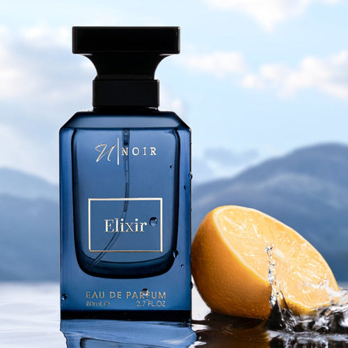 Blue perfume bottle labeled 'Elixir' with a lemon and water splash against a mountainous background