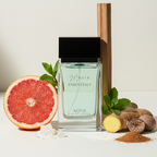Perfume bottle labeled 'Noir Essentials' with a grapefruit, ginger, and mint leaf on a light background