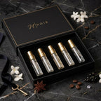 Set of LUXURY OUD perfume bottles in a black box with Noir' branding on a dark marble surface.