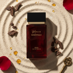 Red perfume bottle labeled 'Noir Essentials' on a textured surface with decorative elements.
