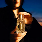 Person holding a perfume bottle with a blurred background